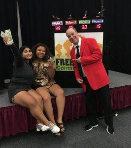Adam posing with two winners of the free money game show